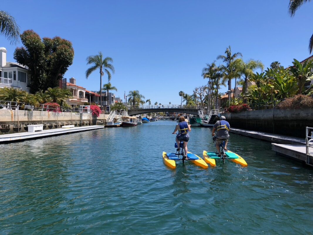 Hydrobikes in the Naples canals lined with palms and homes