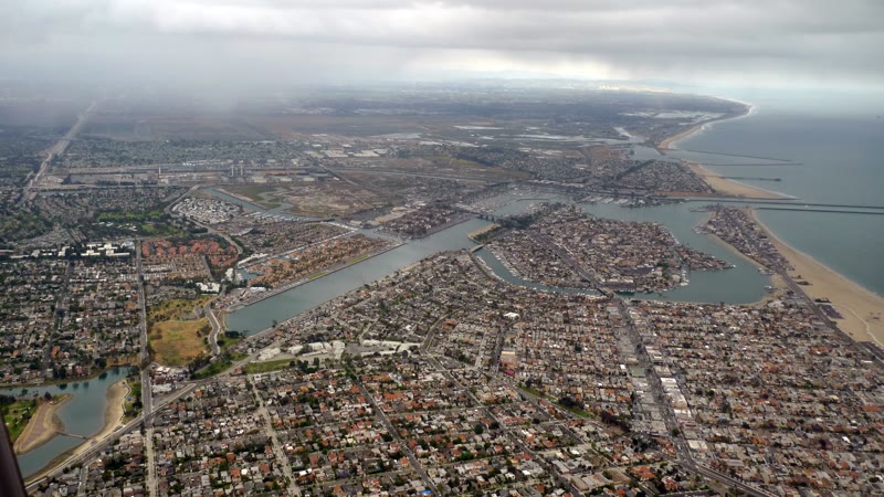 Aerial view of Alamitos Bay and the Naples islands in Long Beach, with the ocean and beach on the right