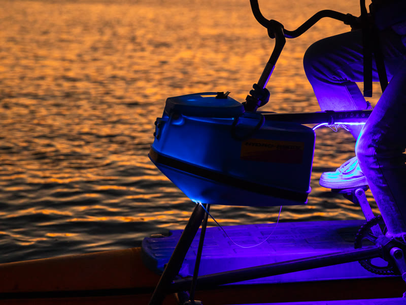 A hydrobike lit with purple LED lights at sunset on Alamitos Bay