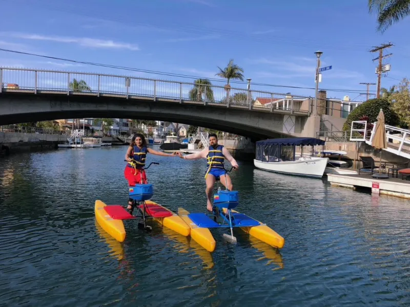 Riders on hydrobikes under a bridge in the Naples canals