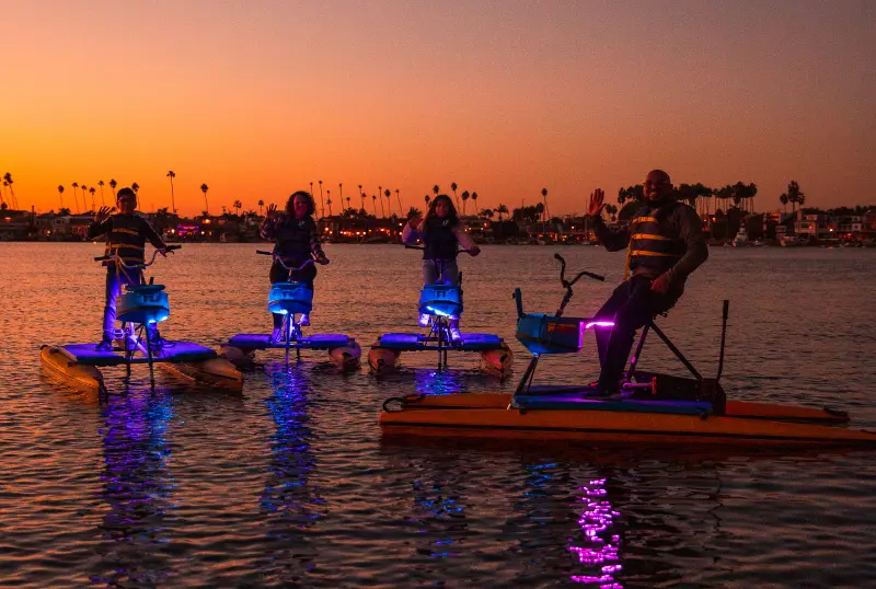 LED-lit hydrobikes on Alamitos Bay at dusk