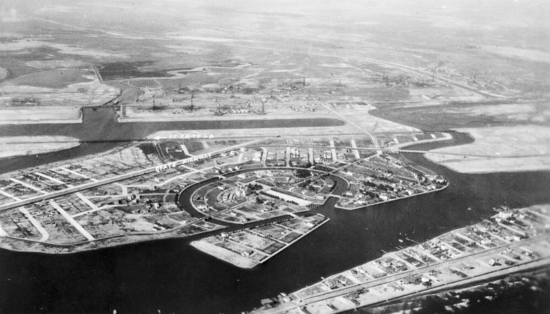 Black and white aerial photo of early Naples around 1915, with a ring-shaped canal, new lots and the state highway
