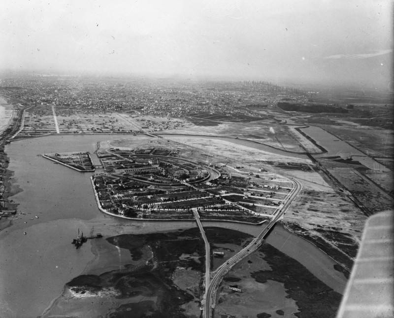 Black and white aerial photo of Naples in 1925, with early homes filling new lots on the island and open land and marsh around Alamitos Bay