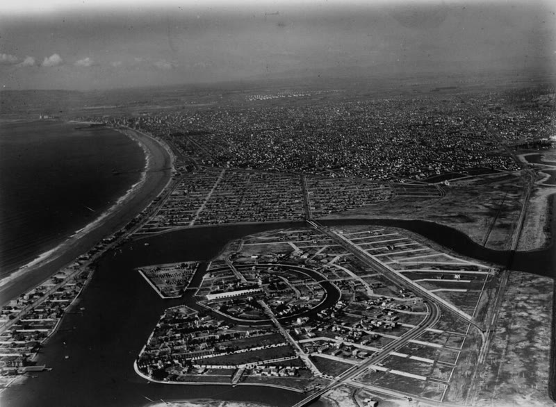 Black and white aerial photo of Naples in 1929, with homes filling the lots around the canals and Long Beach beyond