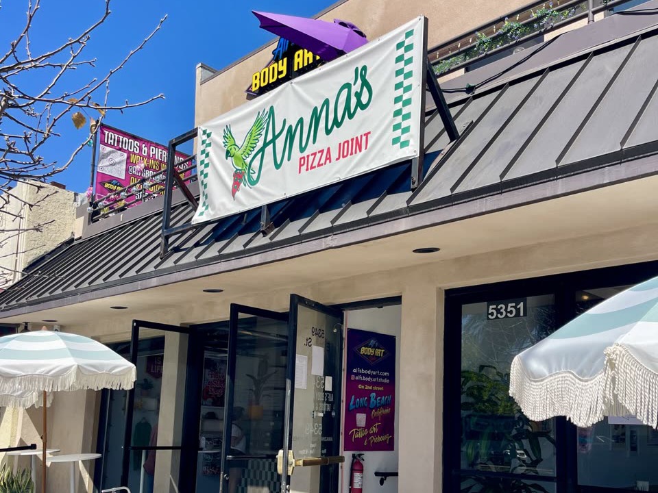 The storefront of Anna's Pizza Joint in Belmont Shore, with its green and white sign over the door