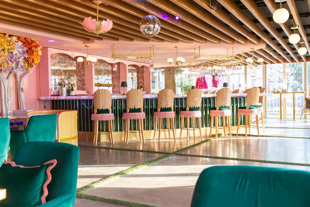 The bar at Nigel's, with seashell-back stools trimmed in pink fringe at a green-tiled bar under a disco ball